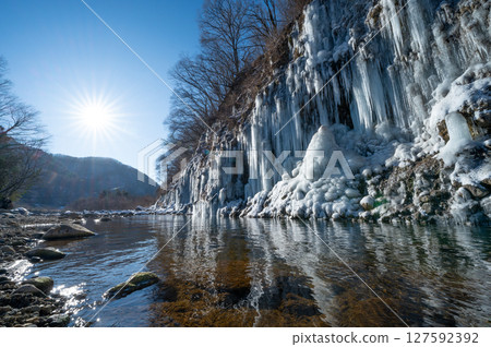 Frozen waterfall and shining sun 127592392