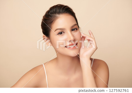 A beautiful young Asian woman with clean, fresh skin against a beige background. Skincare, facial treatment, cosmetology, beauty, and spa. An elegant portrait of an Asian woman. A beautiful young Asian woman with clean, fresh skin against a beige background. Skincare, facial treatment, cosmetology, beauty, and spa. An elegant portrait of an Asian woman. 127592761
