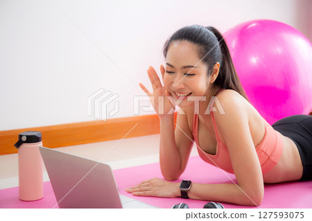 Young asian woman video call with friends after practice yoga and workout for relax in living room. 127593075