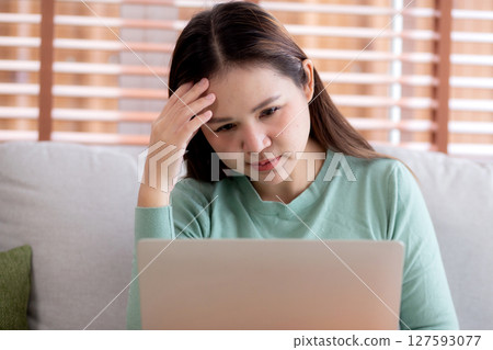 Young asian businesswoman working laptop with stress and frustrated in living room at home. Young asian businesswoman working laptop with stress and frustrated in living room at home. 127593077