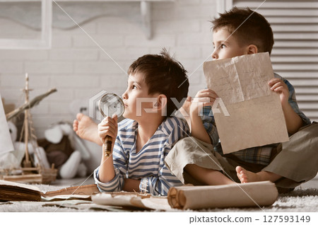 Two boys studying old maps Travel 127593149