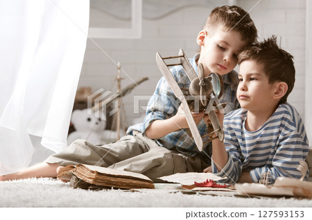 Two boys studying old maps Travel 127593153