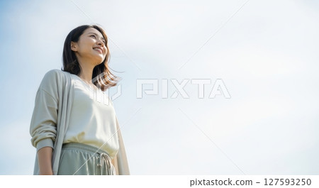 A woman looking up at the sky 127593250