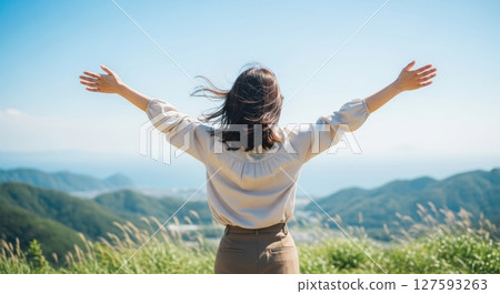 Woman spreading her arms at the summit 127593263
