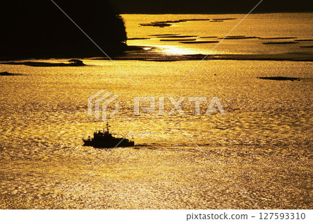 黃昏時分,瀨戶內海上牡蠣筏漂浮,漁船航行 黃昏時分,瀨戶內海上牡蠣筏漂浮,漁船航行 127593310