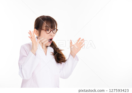 A middle-aged woman in a white coat is surprised A middle-aged woman in a white coat is surprised 127593423