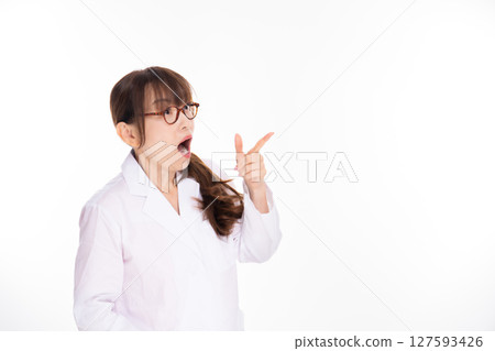 A middle-aged woman in a white coat is surprised 127593426