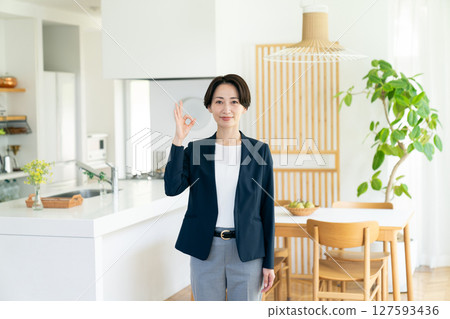 A middle-aged businesswoman introducing a model house 127593436