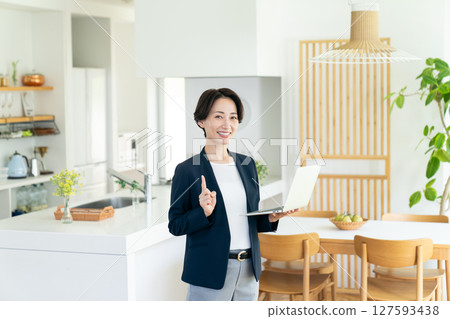 A middle-aged businesswoman introducing a model house 127593438