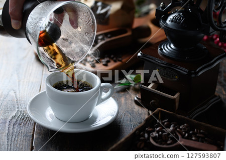 Pouring hot coffee (dark background) Pouring hot coffee (dark background) 127593807