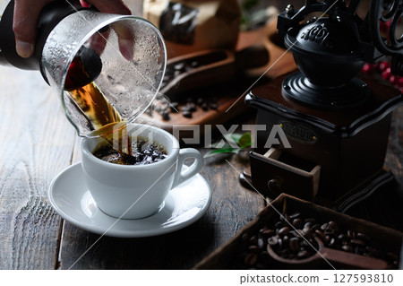 Pouring hot coffee (dark background) Pouring hot coffee (dark background) 127593810