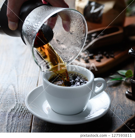 Pouring hot coffee (dark background) 127593811