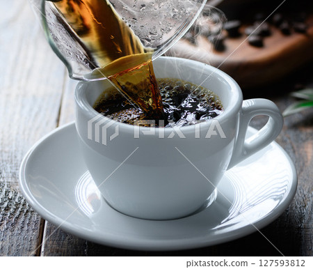 Pouring hot coffee (dark background) 127593812