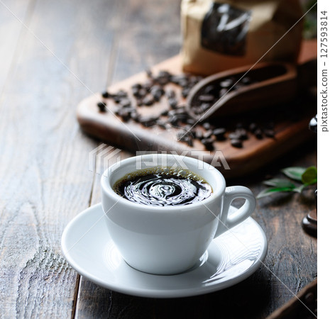 Hot coffee and coffee beans (dark background) 127593814