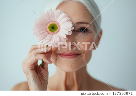 Beautiful old woman hold single pink flower and smile. Beautiful old woman hold single pink flower and smile. 127593971
