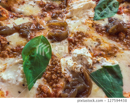 Freshly baked pizza featuring savory meat, creamy cheese, and basil. 127594438