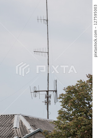 Rooftop TV Antennas Against Grey Sky: Vintage Television Receivers on Slate Roof, Communication Technology, Weather, Rural Scene, Cold Tone Rooftop TV Antennas Against Grey Sky: Vintage Television Receivers on Slate Roof, Communication Technology, Weather, Rural Scene, Cold Tone 127595003