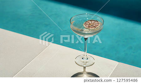 Chill vibes by the pool with a refreshing drink paired with a dried citrus slice Chill vibes by the pool with a refreshing drink paired with a dried citrus slice 127595486