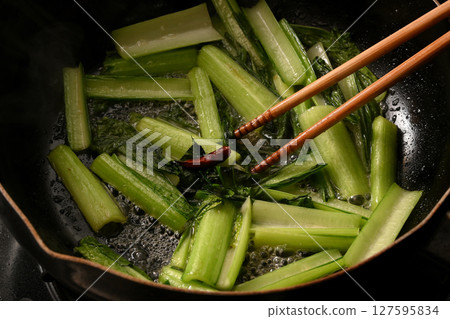 Stir-fried komatsuna greens being cooked 127595834