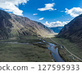 Scenic view of Chulyshman River Valley in Altai. lush green vegetation and towering mountains under cloudy sky. Travel and landscape photography. 127595933