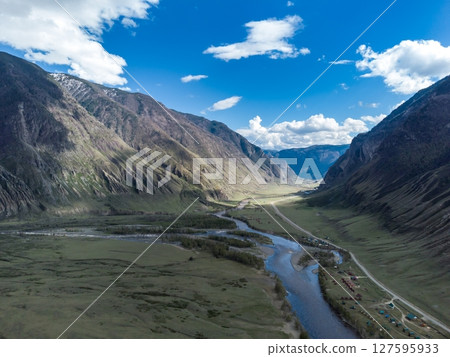 Scenic view of Chulyshman River Valley in Altai. lush green vegetation and towering mountains under cloudy sky. Travel and landscape photography. 127595933