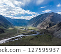 Scenic view of Chulyshman River Valley in Altai. lush green vegetation and towering mountains under cloudy sky. Travel and landscape photography. 127595937