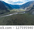 Scenic view of Chulyshman River Valley in Altai. lush green vegetation and towering mountains under cloudy sky. Travel and landscape photography. 127595940