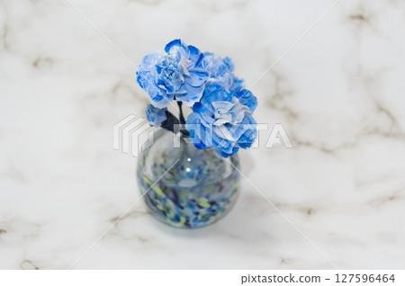 A vase in cool colors in the center features a bud and three carnations A vase in cool colors in the center features a bud and three carnations 127596464
