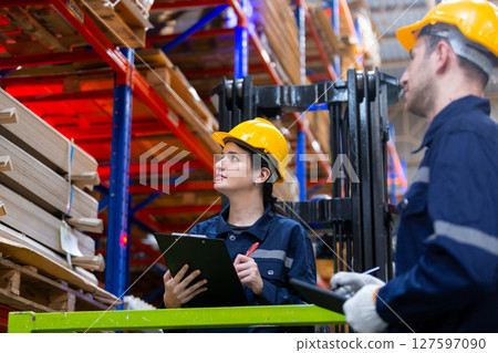 Team warehouse worker checking product cardboard on shelf in storage. Large industry in paper product line manufacturing. Employees counting stock on shelves. 127597090