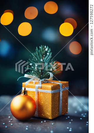 a close view of a gift box with a bow and ball on a festive background of lights, bokeh illuminations, Christmas decoration for New Year holidays, winter season 127598272