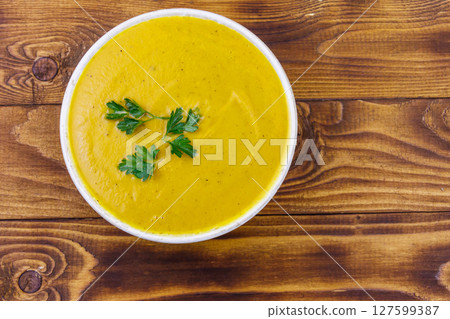 Pumpkin soup on a wooden table. Top view Pumpkin soup on a wooden table. Top view 127599387