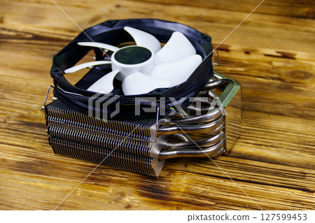 Modern CPU cooler on a wooden desk Modern CPU cooler on a wooden desk 127599453