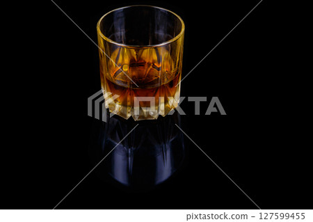 Glass of whiskey on a black background 127599455