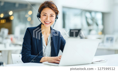 一位呼叫中心女士戴著耳機，微笑地與客戶打交道 127599512