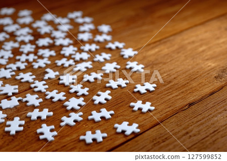 White Puzzle Pieces Spread on Wooden Background in Natural Ambient Lighting 127599852