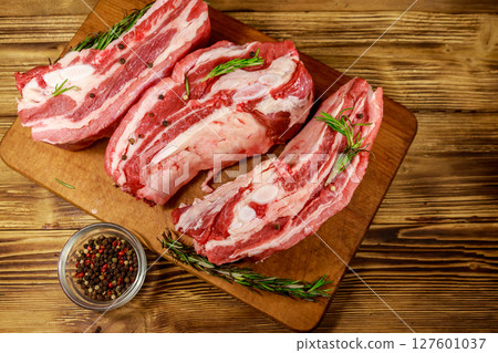 Raw pork ribs with spices and rosemary on wooden table. Top view 127601037
