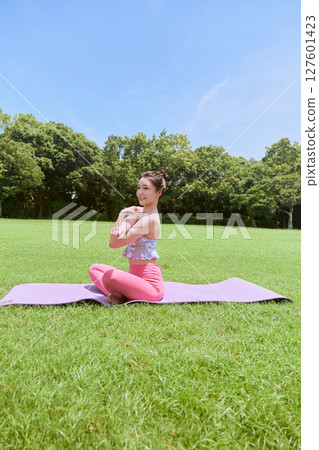 一位女士在天然草坪和藍天下,在度假氛圍中練習瑜伽和普拉提 一位女士在天然草坪和藍天下,在度假氛圍中練習瑜伽和普拉提 127601423