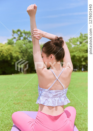 一位女士在天然草坪和藍天下，在度假氛圍中練習瑜伽和普拉提 127601440