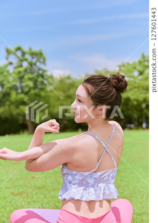 一位女士在天然草坪和藍天下，在度假氛圍中練習瑜伽和普拉提 127601443