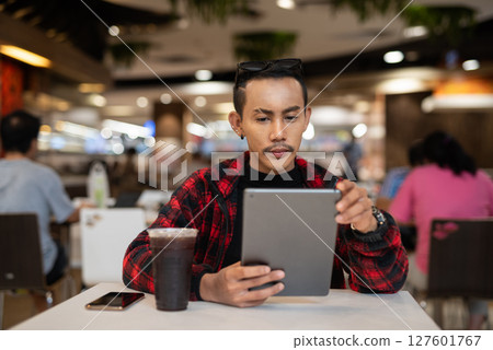 Portrait of nonbinary genderfluid young Asian gay man using digital tablet computer Portrait of nonbinary genderfluid young Asian gay man using digital tablet computer 127601767