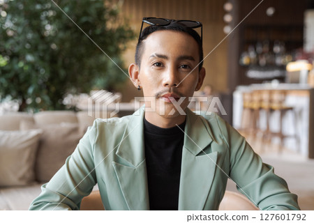 Portrait of nonbinary genderfluid young Asian gay man in coffee shop 127601792