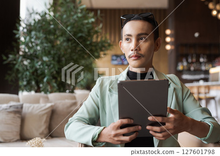 Portrait of nonbinary genderfluid young Asian gay man using digital tablet computer Portrait of nonbinary genderfluid young Asian gay man using digital tablet computer 127601798