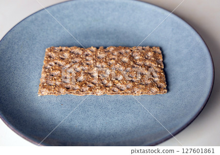 One piece of crunchy crispbread on a plate One piece of crunchy crispbread on a plate 127601861