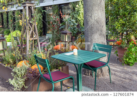 Empty table in autumn garden decorated for Halloween Empty table in autumn garden decorated for Halloween 127601874