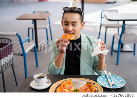 Portrait of nonbinary genderfluid young Asian gay man eating pizza ourdoors Portrait of nonbinary genderfluid young Asian gay man eating pizza ourdoors 127601898