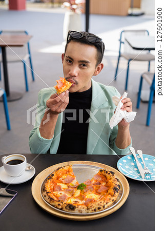 Portrait of nonbinary genderfluid young Asian gay man eating pizza ourdoors Portrait of nonbinary genderfluid young Asian gay man eating pizza ourdoors 127601900