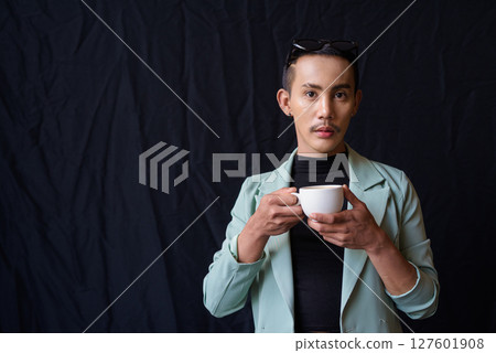 Portrait of nonbinary genderfluid young Asian gay man in studio holding coffee cup 127601908