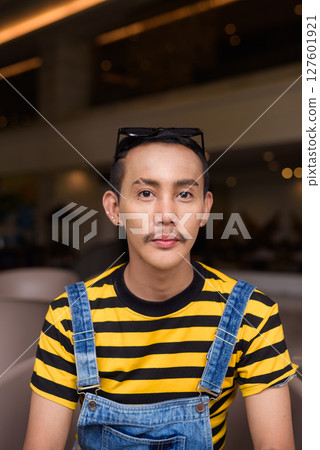 Portrait of nonbinary genderfluid young Asian gay man in coffee shop Portrait of nonbinary genderfluid young Asian gay man in coffee shop 127601921