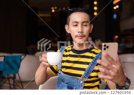 Portrait of nonbinary genderfluid young Asian gay man in coffee shop 127601930