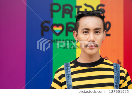 Portrait of nonbinary genderfluid young Asian gay man against pride flag background 127601935